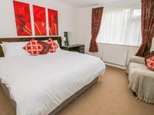 a bedroom with a large white bed and a window at The Dene in Betws-y-coed