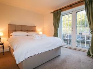 1 dormitorio con cama y ventana grande en The Orangery en Turriff