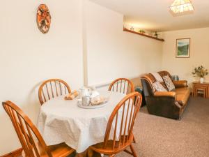 uma sala de jantar com uma mesa e cadeiras e um sofá em Cordwainer Cottage em Stoke-on-Trent