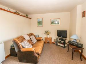 a living room with a couch and a tv at Cordwainer Cottage in Stoke on Trent
