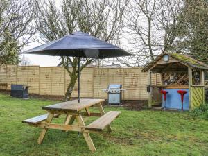 a picnic table with an umbrella on top of it at The Cart House in Liskeard