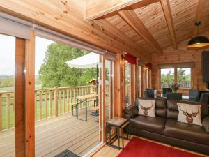 a screened in porch with a couch and a table at Sunnyside Lodge in Crewkerne
