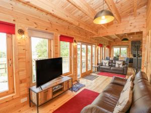 a living room with a large flat screen tv at Sunnyside Lodge in Crewkerne