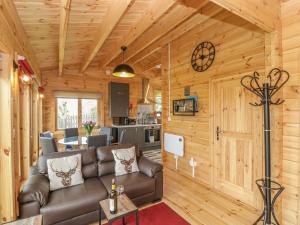 a living room with a couch and a kitchen at Sunnyside Lodge in Crewkerne