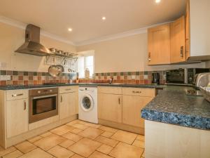 a large kitchen with a washer and dryer in it at The Coach House in Truro