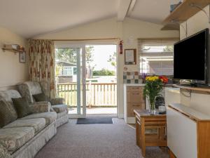 a living room with a couch and a tv at Chalet 186 in Padstow