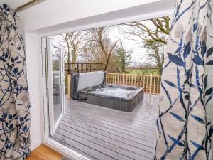 a room with a hot tub on a deck at Crooked Hill Cottage in Ammanford
