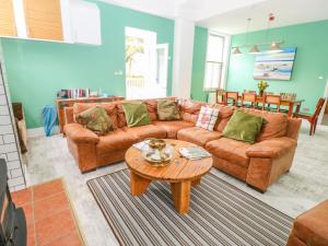 a living room with a brown couch and a table at The Old Kitchens in Totland