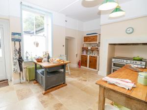a kitchen with a table and a stove at The Old Kitchens in Totland