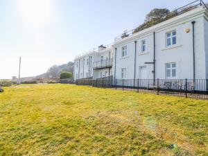 a row of white buildings on a grass field at The Old Signal House in Torpoint