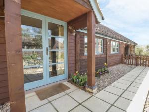 una casa con una puerta y flores en un patio en Shippon Barn, en Yeovil