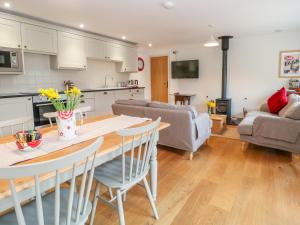 a kitchen and living room with a table and chairs at Shippon Barn in Yeovil