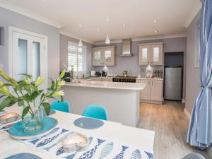 a kitchen and living room with a table and chairs at Gadlys in Trearddur