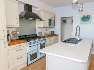 a kitchen with white cabinets and a stove top oven at Shady Bowers in Carnforth