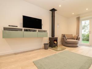 a living room with a fireplace and a tv at Kober House in Helston