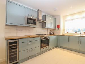 a kitchen with stainless steel cabinets and a stove top oven at Kober House in Helston