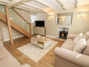 a living room with a couch and a fireplace at Tan Y Goeden in Pwllheli