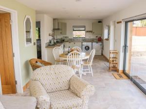 a living room with a couch and a table and a kitchen at Black Cat Bach in Abergavenny