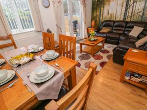 a living room with a table and a couch at Ty Cerrig in Ammanford