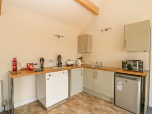 a kitchen with white cabinets and a counter top at Derwent House Farm in Malton