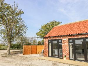 une maison en briques avec un toit orange dans l'établissement Derwent House Farm, à Malton