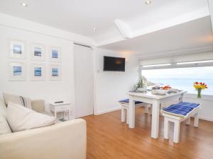 a living room with a white couch and a table at The Loft at Beach House in St Austell