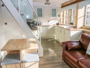 a living room with a couch and a stair case at Riverview Cottage in Holmfirth