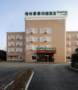een lege parkeerplaats voor een gebouw bij Greentree Inn Shanghai West Huaxia Road Metro Station Express Hotel in Shanghai