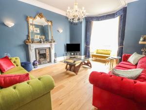 a living room with two couches and a fireplace at Beaulieu House in Llandudno