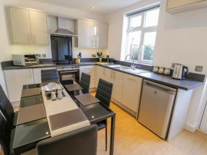 a kitchen with a table and a dining room at Arnant in Dolgellau