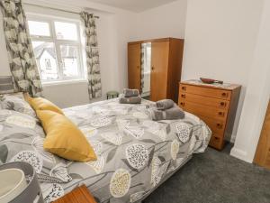 a bedroom with a bed and a dresser and a window at Arnant in Dolgellau