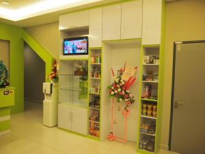 a room with a refrigerator and a tv on a wall at Star Bay Hotel in Lumut