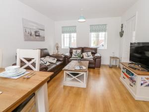a living room with a couch and a tv at Bayside Cottage in Filey