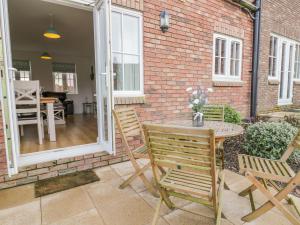 a patio with a table and chairs and a brick wall at Bayside Cottage in Filey