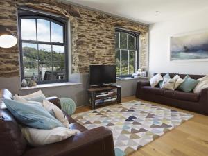 a living room with two couches and a tv at 3 The Pottery in Dartmouth