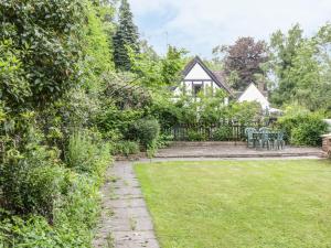 a garden with chairs and a house in the background at Bridge View Cottage in Telford