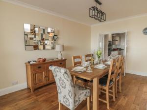 a dining room with a wooden table and chairs at Beach Cove View in Newbiggin-by-the-Sea
