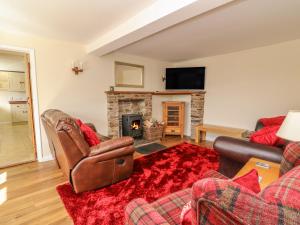 a living room with two couches and a fireplace at Treboeth in Knighton