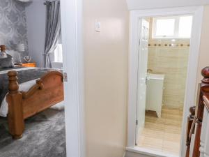 a bedroom with a bed and a door leading to a bathroom at Beach Cove View in Newbiggin-by-the-Sea +27 photos