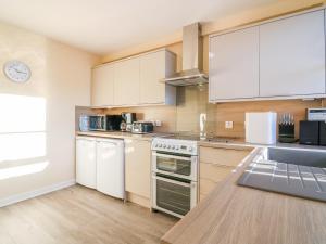 a kitchen with white cabinets and a counter top at 6 Aonachan Gardens in Spean Bridge