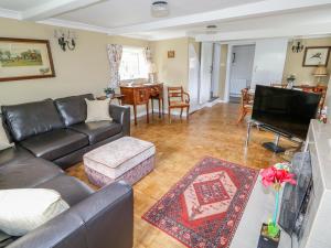 uma sala de estar com um sofá e uma televisão em The Cottage em Skegness