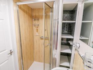 une douche avec une porte vitrée dans une salle de bain dans l'établissement The Cottage, à Skegness 33 autres photos