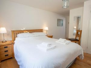 een slaapkamer met een groot wit bed en handdoeken bij 1 Lyndhurst in Salcombe