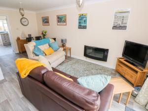 a living room with a couch and a tv at Cranford Cottage in Pembroke