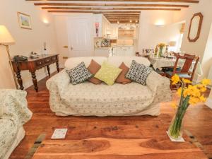 uma sala de estar com um sofá com almofadas em The Coach House em Berwick-Upon-Tweed