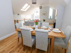 a dining room and living room with a wooden table and chairs at Mor Awelon in Goodwick