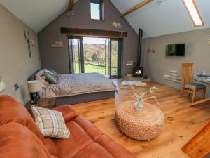 a living room with a couch and a bed at Thompson Rigg Barn in Scarborough