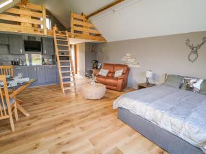 a bedroom with a bed and a kitchen and a loft at Thompson Rigg Barn in Scarborough