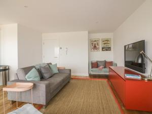 a living room with a couch and a tv at Onshore 7 in Newquay