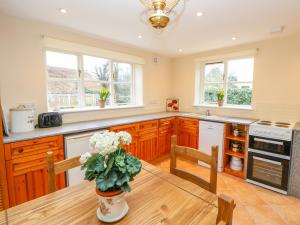a kitchen with a table with a vase of flowers on it at Rose Cottage in Darlington